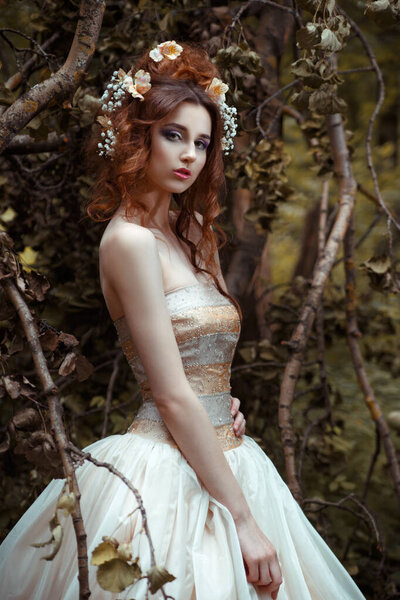 Portrait of bride in long flowing dress in mysterious forest