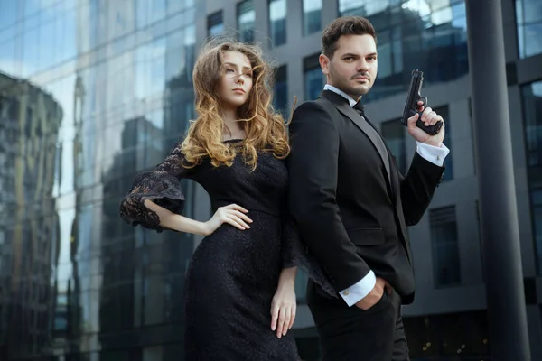 Elinde tabancaları olan zarif bir adam güzel bir kızı korur..