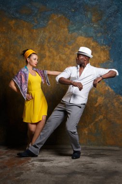 Zarif siyah adam ve güzel beyaz kadın salsa yapıyor..