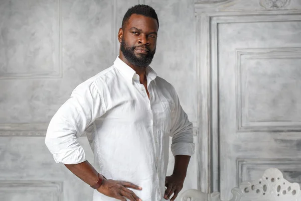 Black man with a beard in a white shirt.