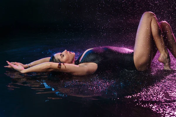 Красивая Сексуальная Девушка Купальнике Лежит Спине Каплями Падающей Воды Фиолетовой — стоковое фото