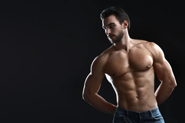 Siyah bir arka planda çıplak gövdesi olan genç bir atletik..