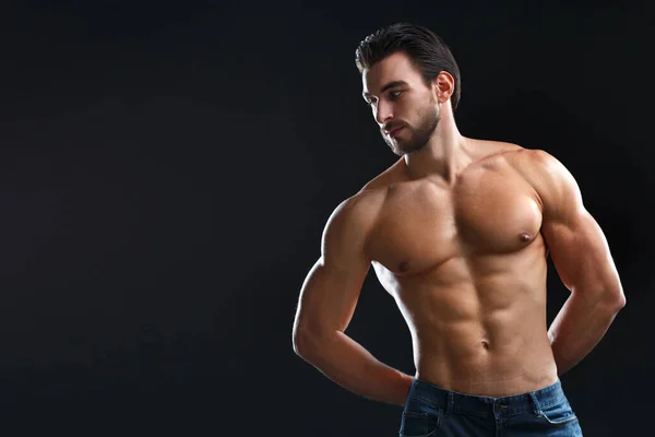 Siyah bir arka planda çıplak gövdesi olan genç bir atletik..