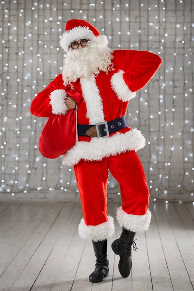 Мужчина Костюме Санта Клауса Танцует Мешком Подарков Руках Яркой Комнате — стоковое фото