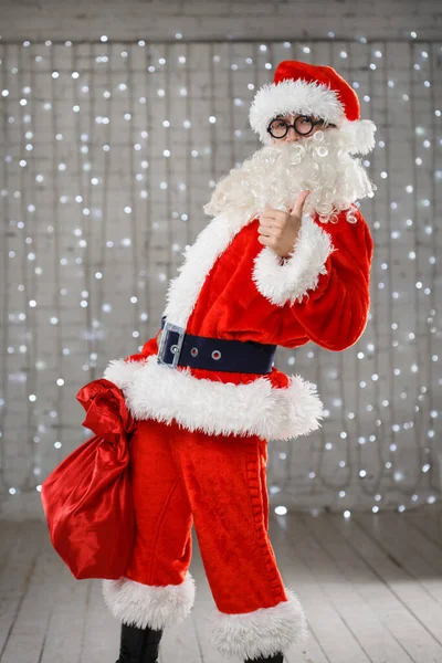 Человек Костюме Санта Клауса Мешком Подарков Одной Руке Другой Показывает — стоковое фото