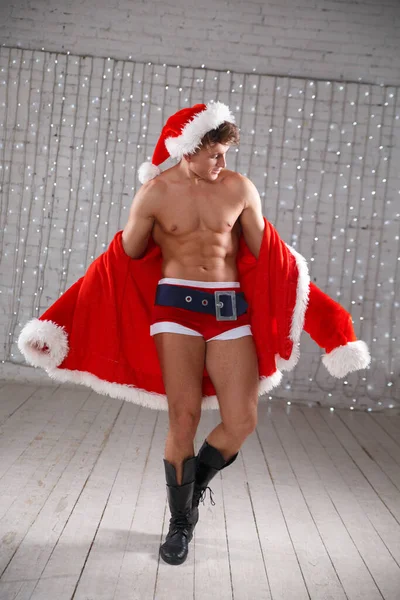 Kötü Noel Baba kostümlü kaslı genç adam..