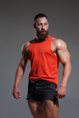 Kırmızılı kaslı sakallı adam gri arka planda izole edilmiş..