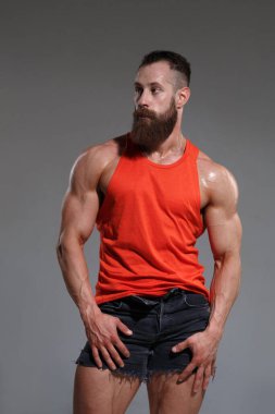 Kırmızılı kaslı sakallı adam gri arka planda izole edilmiş..