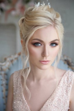 Zarif bir sarışın gelinin zarif portresi. İç tarafta açık pembe bir elbise içinde..