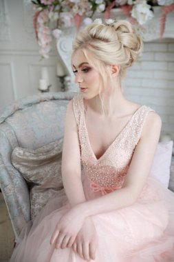 Zarif bir sarışın gelinin zarif portresi. İç tarafta açık pembe bir elbise içinde..