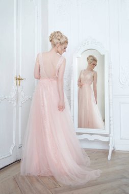 Ayna yakınında parlak bir iç mekanda zarif sarışın gelin..