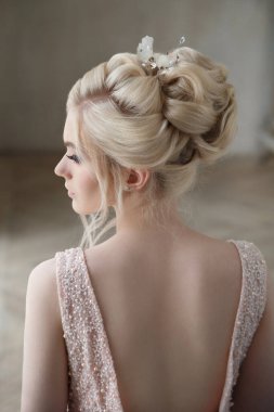 Şık bir düğün saç stili olan sarışın bir gelin portresi..