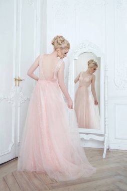 Ayna yakınında parlak bir iç mekanda zarif sarışın gelin..