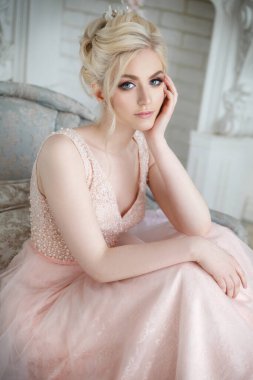 Şık bir iç mekanda zarif bir düğün saç stili olan güzel bir gelinin nazik portresi..