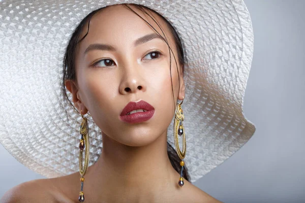 Geniş kenarlı şapkalı güzel bir Asyalı kızın güzel portresi..