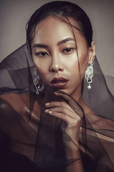 Siyah şeffaf kumaşlı güzel bir Asyalı kızın güzel portresi..