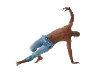 Kot pantolonlu atletik genç siyah bir adam ve beyaz arka planda çıplak bir gövde ile dans ediyor..