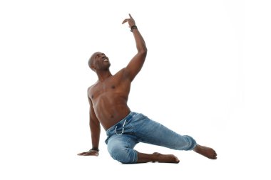 Kot pantolonlu atletik genç siyah bir adam ve beyaz arka planda çıplak bir gövde ile dans ediyor..