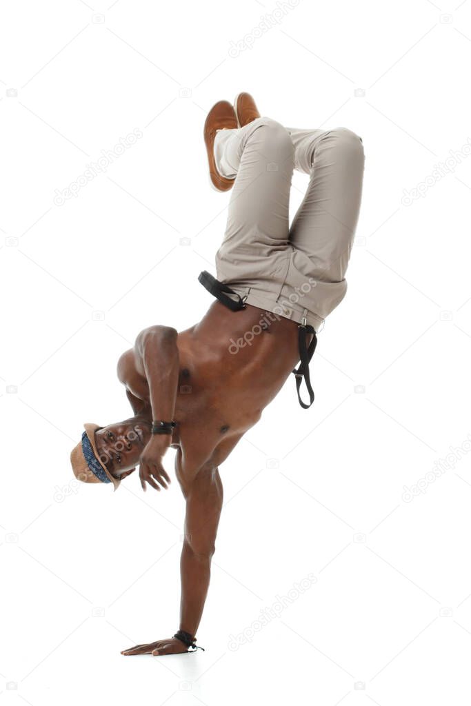 Stylish black male dancer balancing on one hand isolated on white background.