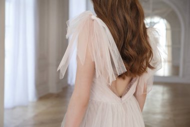 İnce bir kızın üzerindeki zarif pudralı gelinliğin ayrıntıları..