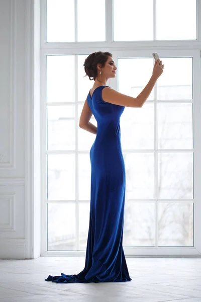 창문을 향하여 드레스를 아름다운 소녀의 실루엣이 셀카를 만든다 — 스톡 사진