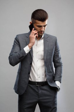 İş elbisesi giymiş genç bir Asyalı telefonda konuşuyor. Gri bir geçmişi var..