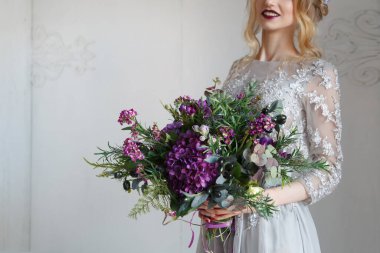 Mor ortanca buketi, zeytin dalları ve gelinin ellerinde sulu bitkiler..