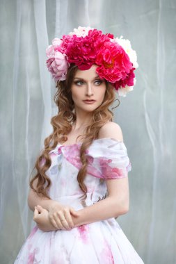 Açık havada bir yaz günü parlak bir şakayık çelengi içindeki güzel bir kızın narin portresi..