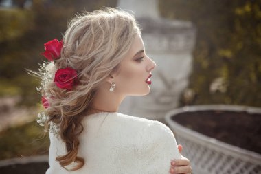 Hoş, şehvetli, sarışın gelin, zarif saç stili, çiçeklerle süslenmiş, dışarıda..