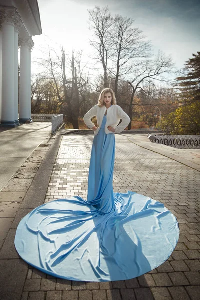 在秋天的公园里 美丽的新娘穿着一件失重的蓝色高级长裙 — 图库照片