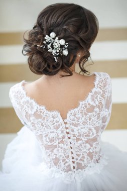 Güzel, şık bir gelinin portresi. Arkadan zarif bir saç stili..