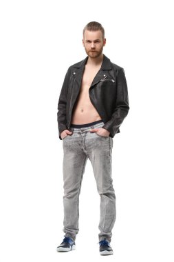 Charismatic bearded man in a unbuttoned leather jacket on his naked body stands in full growth isolated on white background. clipart