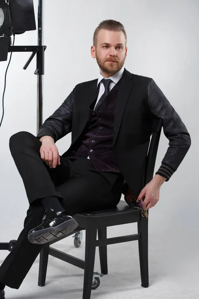 Homem Elegante Terno Três Peças Sentado Uma Cadeira Fundo Cinza — Fotografia de Stock