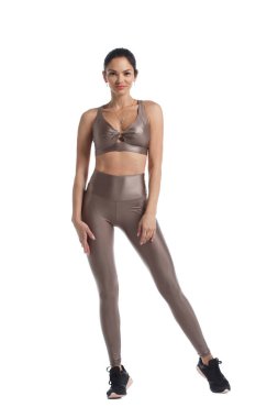 Beyaz arka planda izole edilmiş bej spor giyimli ince kız jimnastikçi..