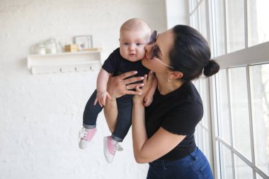 Kollarında bebeği olan şık bir anne..