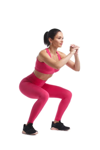 Schlankes Mädchen Pinkfarbener Sportbekleidung Macht Kniebeugen Isoliert Auf Weißem Hintergrund — Stockfoto