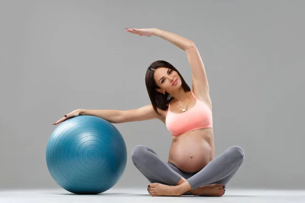 有运动能力的孕妇带着球参加体育运动 — 图库照片