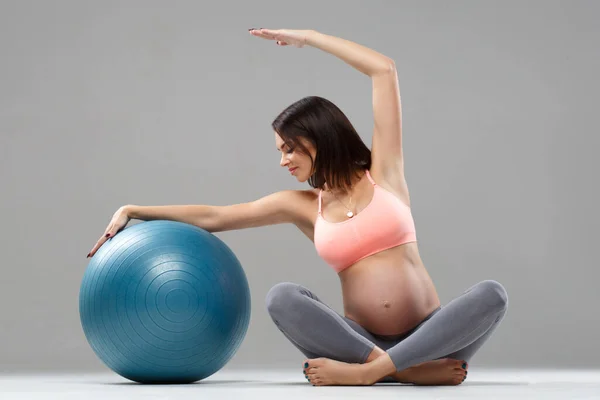 Athletic pregnant woman goes in for sports with the ball.