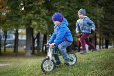 Bir çocuk bir koşucuyu yüzüstü bırakıyor ve ikincisi onu sonbahar parkında yakalıyor..