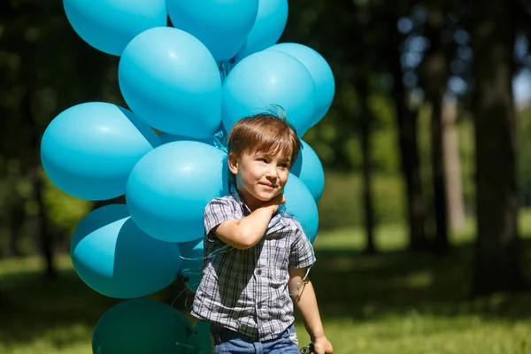 Mały Chłopiec Biega Parku Wielką Bandą Niebieskich Balonów — Zdjęcie stockowe