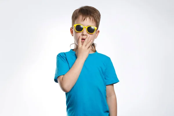 一个穿着蓝色衣服 戴着太阳镜 情绪激动的小男孩感到惊讶 — 图库照片