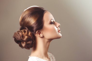 Profilde izole edilmiş dekoratif şapkalı tatlı esmer bir gelinin klasik portresi..