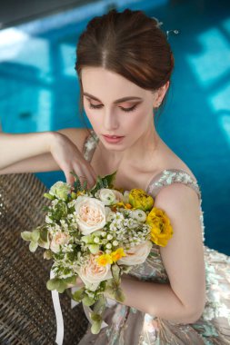 Mavi suların arka planında zarif gelinin güzel portresi.