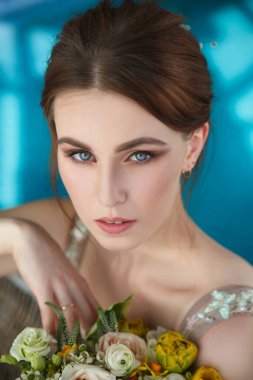 Mavi suların arka planında zarif gelinin güzel portresi.