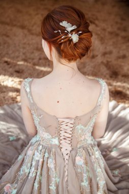 Güzel kızıl saçlı gelin, arkadan zarif bir saç stili..