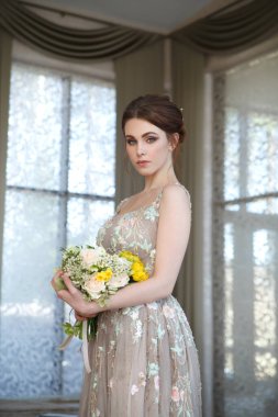 Pencere arkasında elinde buket olan sevimli bir kız gelinin portresi..