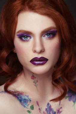 Yaratıcı bir gece makyajıyla parlak kızıl saçlı bir kızın güzel portresi..