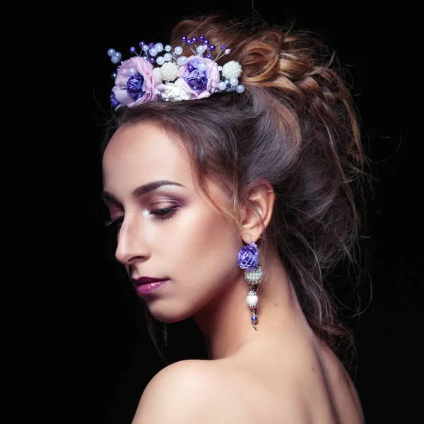 Beauty portrait of a beautiful woman with a tiara and earrings handmade