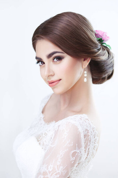 Portrait of a beautiful brunette bride flirty makeup and hairstyle in lace