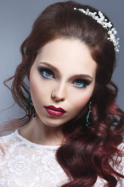 Gri arkaplanda zarif saç stili olan güzel bir esmer gelinin güzel portresi..